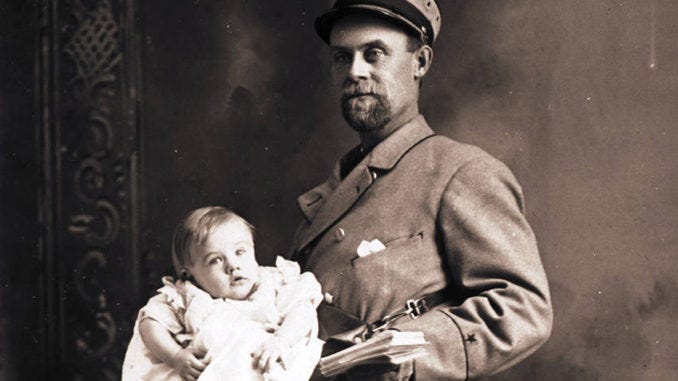 A postal worker carrying a baby along with letters